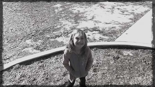 Portrait of young woman standing on grass