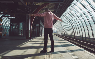 Rear view of man standing on railroad station platform