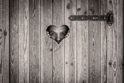 Close-up portrait of a smiling on wooden door