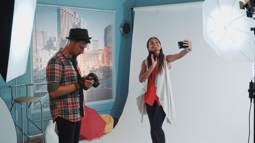 Young woman taking selfie in studio