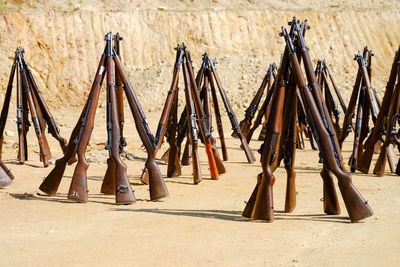 Wooden poles on field against wall