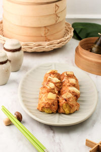 Shumai dimsum with mentaiko spicy sauce. served on ceramic plate with mozarella on top