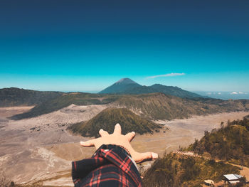 Rear view of man on mountain range against clear blue sky
