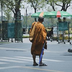 Rear view of woman walking on road