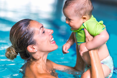 Mother and son swimming in pool