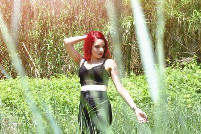 Full length of woman standing on field in forest