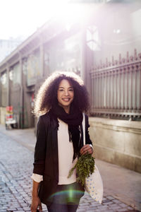 Portrait of smiling woman standing on city street