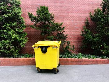 Yellow toy car on footpath against building