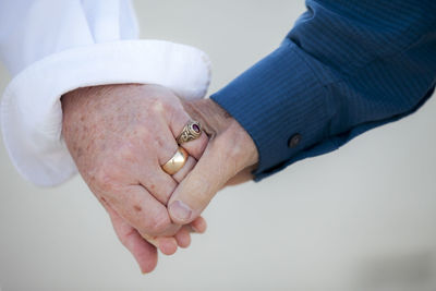 Close-up detail shot of older couple's hands holding each other