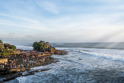 Group of people on beach against sky