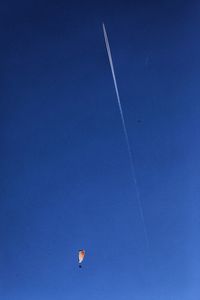 Low angle view of vapor trail against blue sky