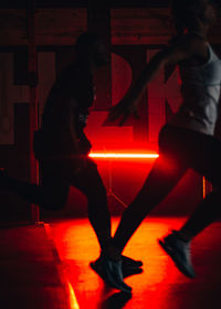 Silhouette people walking in illuminated corridor