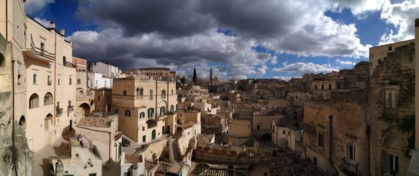 Panoramic view of buildings in town against sky