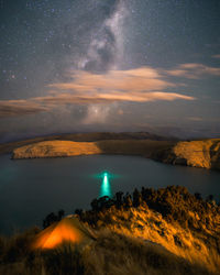 Scenic view of lake and mountains against sky at night