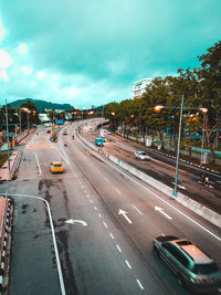 High angle view of vehicles on road against cloudy sky