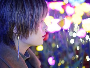Close-up of woman looking at illuminated lights