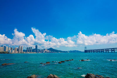 Panoramic view of sea and modern buildings against sky