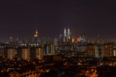 Illuminated cityscape against sky at night