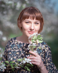 Young woman portrait on the blooming apple trees background