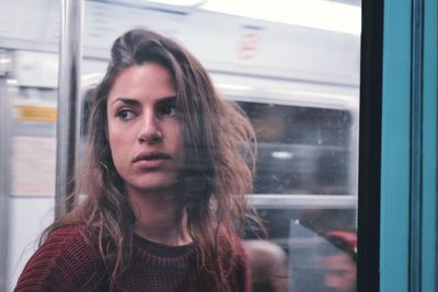 Close-up of young woman looking through window