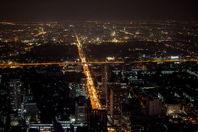 High angle view of illuminated city against sky at night