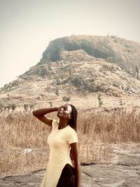 Side view of woman standing against mountain