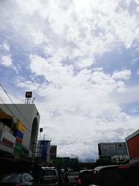 Cars on road amidst buildings in city against sky