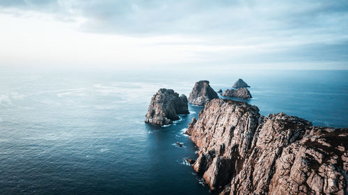 Scenic view of rocks in sea against sky