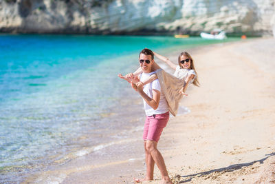 Full length of young woman standing at beach