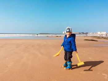 Full length of boy on beach against sky