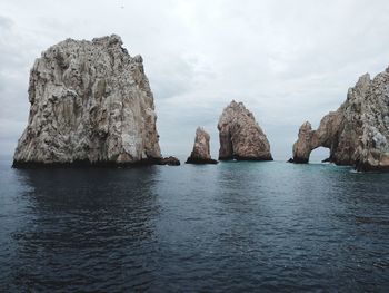 Panoramic view of rock formation in sea against sky