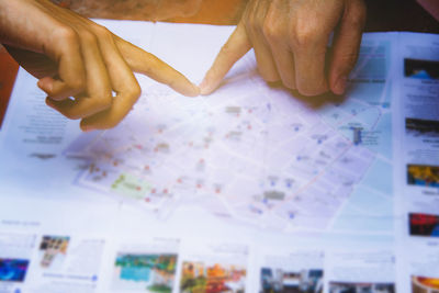 Midsection of people holding paper