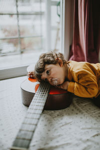 Portrait of child playing guitar at home
