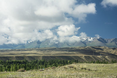 Scenic view of field and mountains against cloudy sky