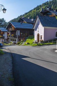 Road by buildings against sky in city