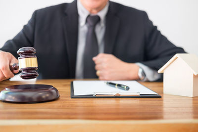 Midsection of man using mobile phone while sitting on table