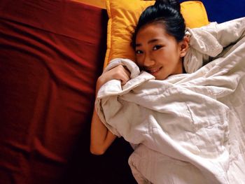 High angle view of woman relaxing on bed