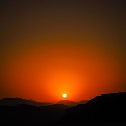 Scenic view of silhouette landscape against orange sky