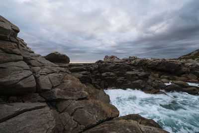 Rocks on beach against sky