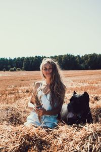 Smiling young woman sitting on a field