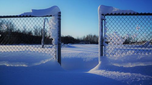 Snow covered field against blue sky