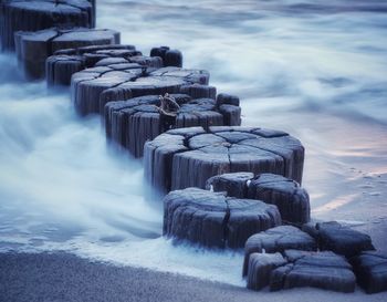 Stone wall on sea shore against sky