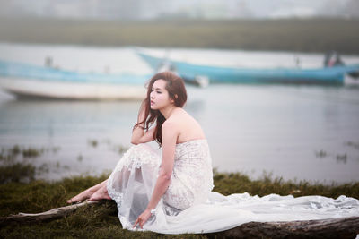 Young woman sitting on shore