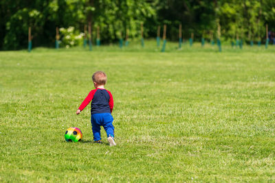 Boy playing with ball on field
