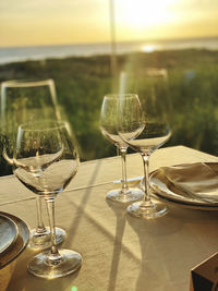 Glass of wine on table at sunset