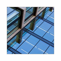 Low angle view of glass building against clear sky