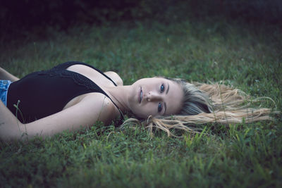 Portrait of woman lying on grass