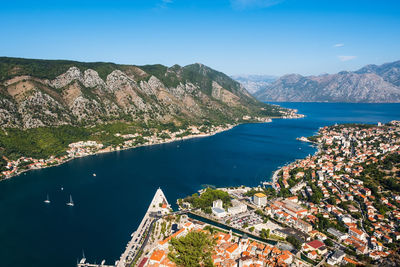 High angle view of buildings by sea against blue sky