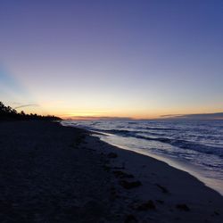 Scenic view of beach against clear sky during sunset