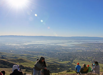 Rear view of people on landscape against clear sky